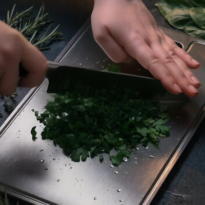Titanoré Labs titanium cutting board — chopping fresh herbs
