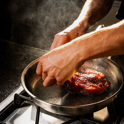 Titanoré Labs Chef's Pan — searing steak on the stovetop